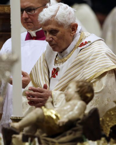 Pope Benedict XVI walks past the statue of baby Jesus in St. Peter’s Basilica. (Associated Press)