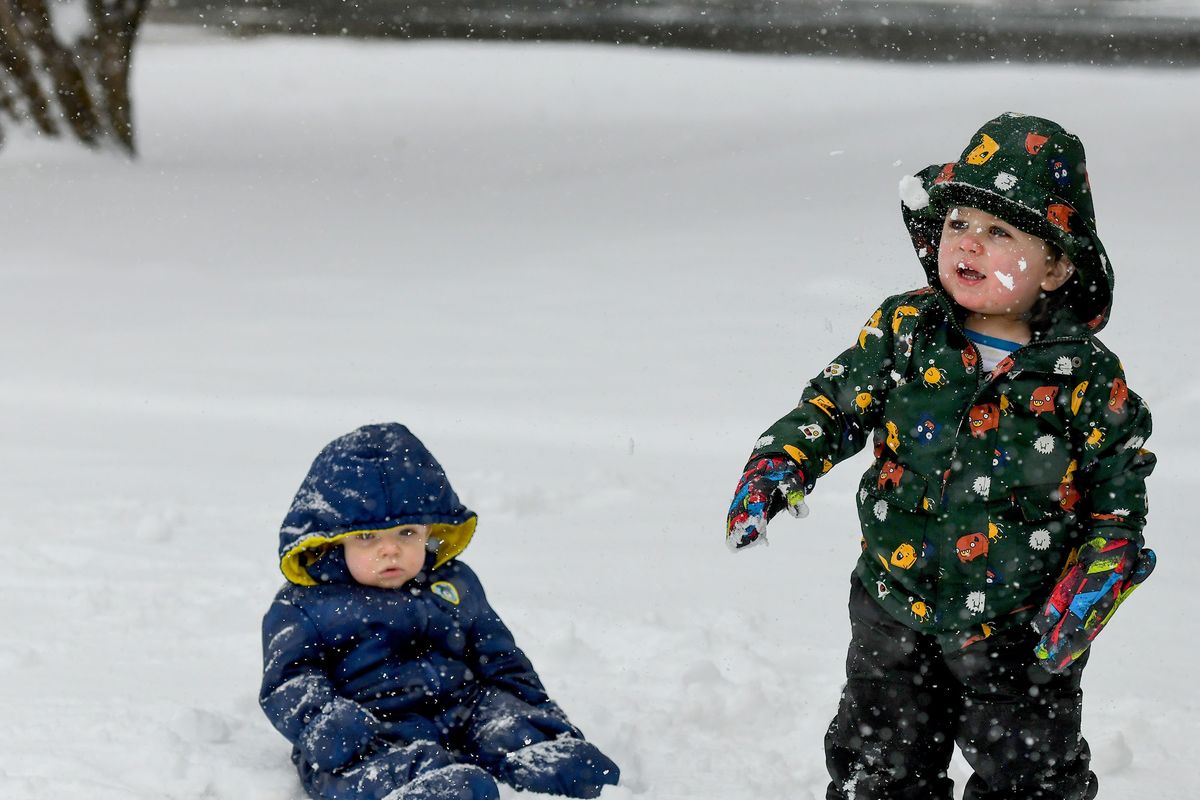 A.J. Christensen, 22 months, right plays in the snow with his little brother Hoyt, 7 months in front of their Post Falls home on Friday, March 10, 2023.  (Kathy Plonka/The Spokesman-Review)