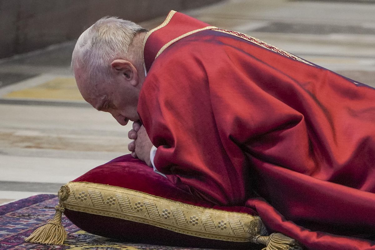 Pope Francis lies down in prayer prior to celebrate Mass for the Passion of Christ, at St. Peter