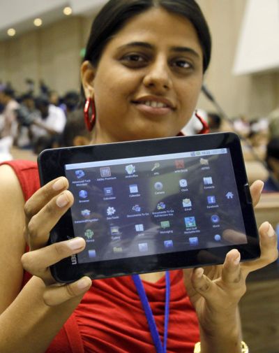 An Indian student poses with the Aakash tablet computer during its launch in New Delhi, India. The Indian government intends to deliver 10 million tablets to students. (Associated Press)
