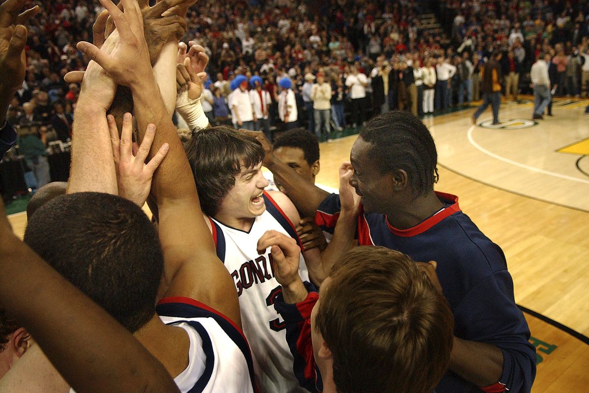 GU’s Adam Morrison, center, is mobbed by teammates after nailing a 3-pointer to beat Oklahoma State at the KeyArena in 2005. (File)