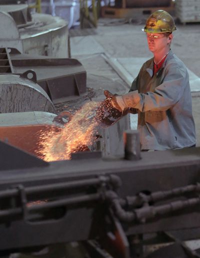 A worker puts additives into a furnace at Rochester Metal Products Corp. in Rochester, Ind., in early May. (Associated Press)