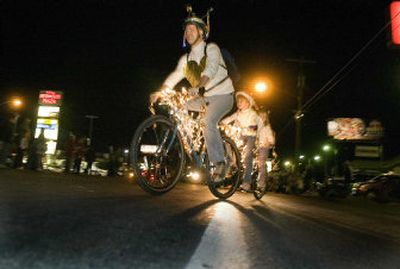 
Tim Wight  rides with his daughters Rachel, middle, and Ellen  on their bicycle made for three Friday in the Valleyfest parade along Sprague Avenue. They called their lighted bike 