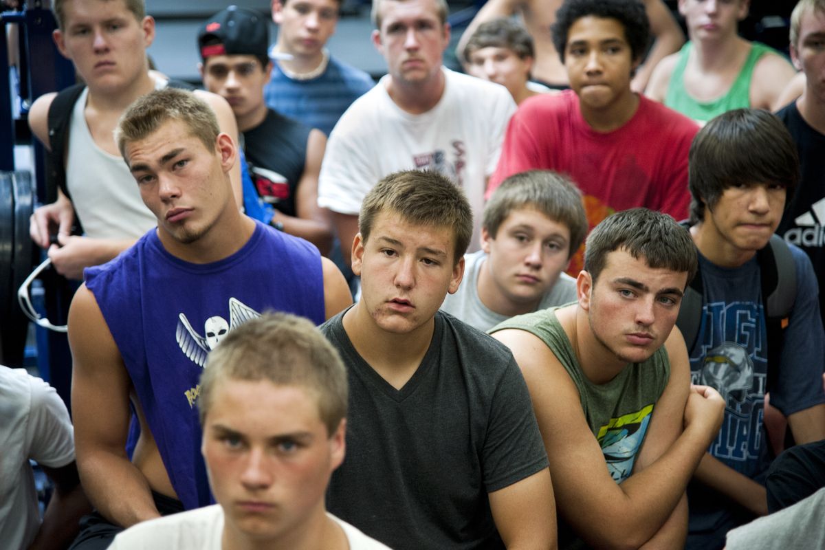 In foreground from left, Rogers football players Brandon Rose, Storm Fissette (front), Jordan Roth and Cody Risinger listen to coach Matt Miethe during the season’s first gathering on Aug. 16.