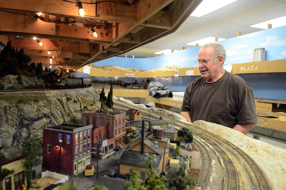 River City Modelers member Bob Deem watches his train as he slowly brings it up to speed on the elaborate train layout at the RCM club in Spokane Friday.