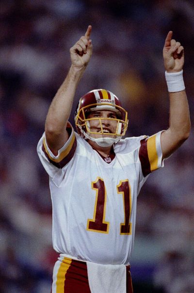 Mark Rypien of the Washington Redskins celebrating with both hands held high in the air in 1992. (File / Associated Press)
