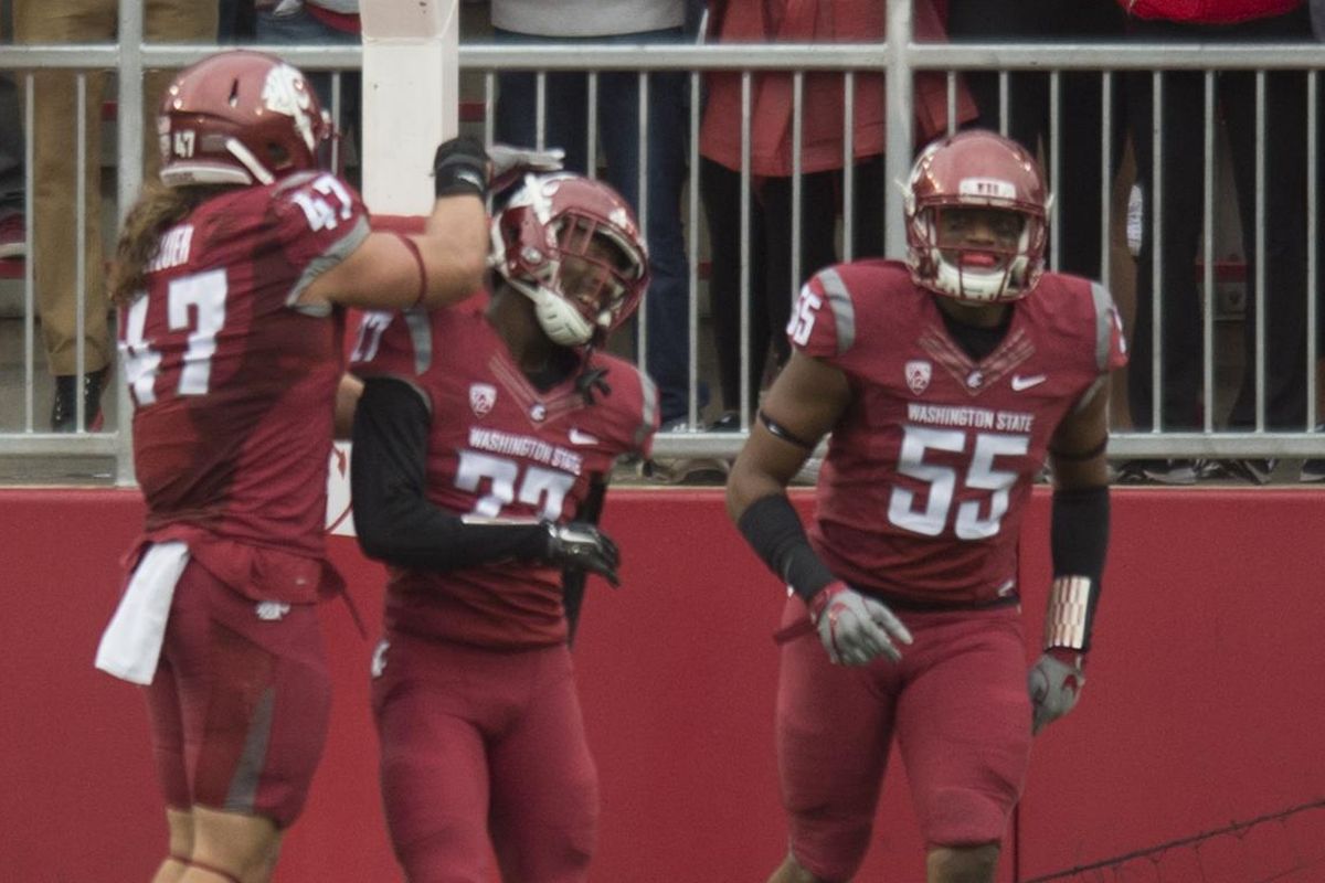WSU’s Marcellus Pippins, center, was swamped by teammates before he could perform his celebration dance after scoring a TD on a blocked kick. (Tyler Tjomsland / The Spokesman-Review)