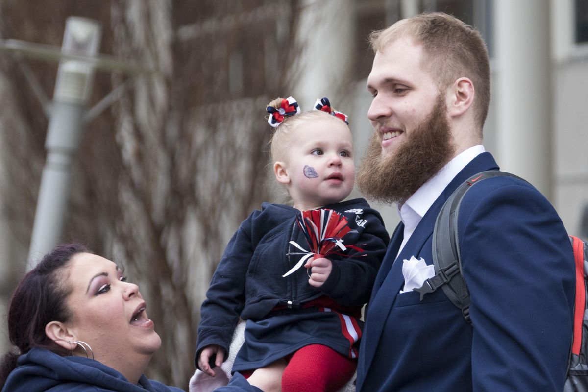Megan Stokes holds her toddler, Emmalynn Stokes, up for a photo with her favorite Gonzaga Bulldog player, Przemek Karnowski, at Gonzaga University as the team walks to the bus to take them to the airport for their flight to Phoenix on Wednesday, March 29, 2017. (Jesse Tinsley / The Spokesman-Review)