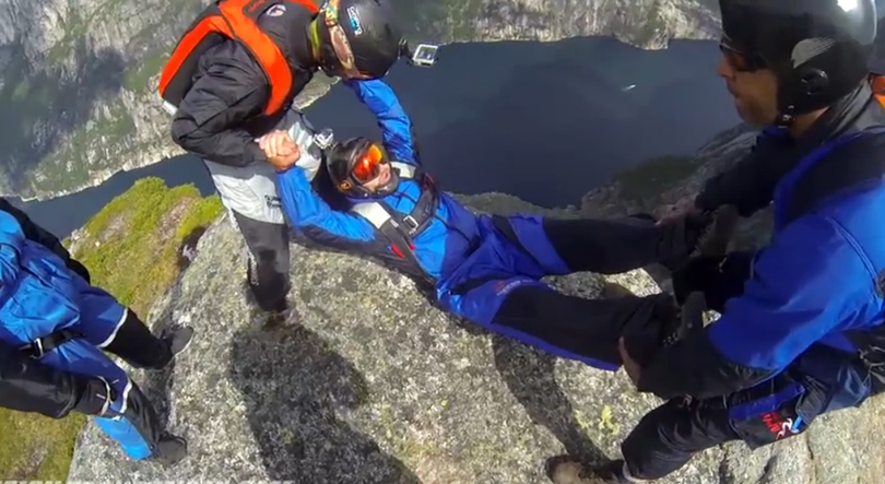 Friends prepare to toss Oregon BASE jumper Blake Burwell off a famous cliff in Norway.