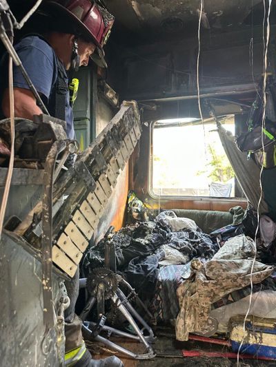 A Spokane firefighter surveys the damage of an RV fire Friday night at Camp Hope in East Central Spokane.   (Courtesy of Spokane Fire Department)