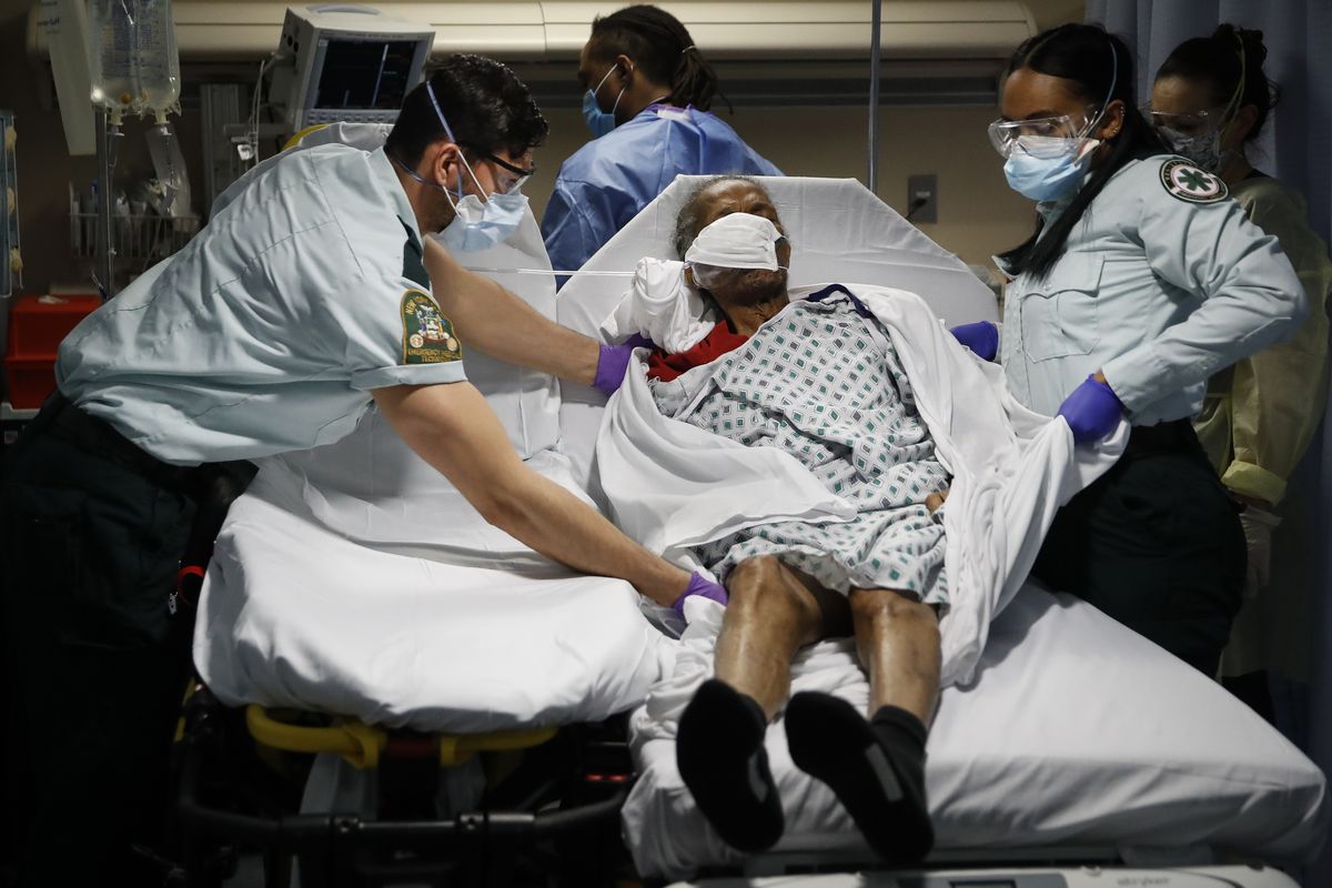 FILE - In this April 20, 2020, file photo emergency medical technicians transport a patient from a nursing home to an emergency room bed at St. Joseph's Hospital in Yonkers, N.Y. A grim blame game with partisan overtones is breaking out over COVID-19 deaths among nursing home residents, a tiny slice of the population that represents a shockingly high proportion of Americans who have perished in the pandemic.  (John Minchillo)
