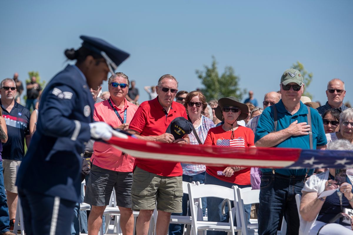 Veterans and their families watch as honor guard members ceremonially unfold and refold a flag as the other honor guard members from Fairchild Air Force Base offered a gun salute, followed by "Taps" at the Memorial Day observance at the Washington State Veterans Cemetery in Medical Lake Monday, May 29, 2023.  (Jesse Tinsley/THE SPOKESMAN-REVIEW)