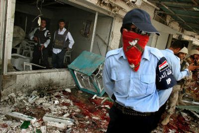 
Iraqi police and military personnel walk through the wreckage on the bloodstained floor of a Baghdad restaurant blown up by a suicide bomber on Sunday. 
 (Associated Press / The Spokesman-Review)