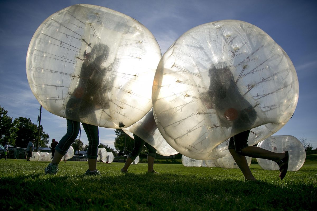 Kids run into each other inside of inflatable balls during the Eclipse Fest 2017 event held in Weiser, Idaho, Sunday, Aug. 20, 2017. Weiser will see 2 minutes and 5 seconds of totality from the solar eclipse on Monday. (Kyle Green / Idaho Statesman via AP)