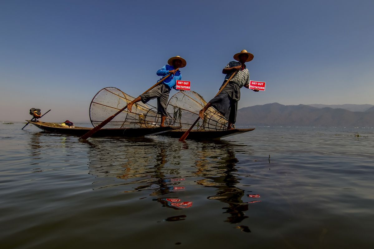 Ethnic Entha fishermen display placards during a protest against the military coup on Inle Lake, Taunggyi, Myanmar Thursday, Feb. 11, 2021. Large crowds demonstrating against the military takeover in Myanmar again defied a ban on protests Thursday, even after security forces ratcheted up the use of force against them and raided the headquarters of the political party of ousted leader Aung San Suu Kyi a day earlier. (Aung Ko San)
