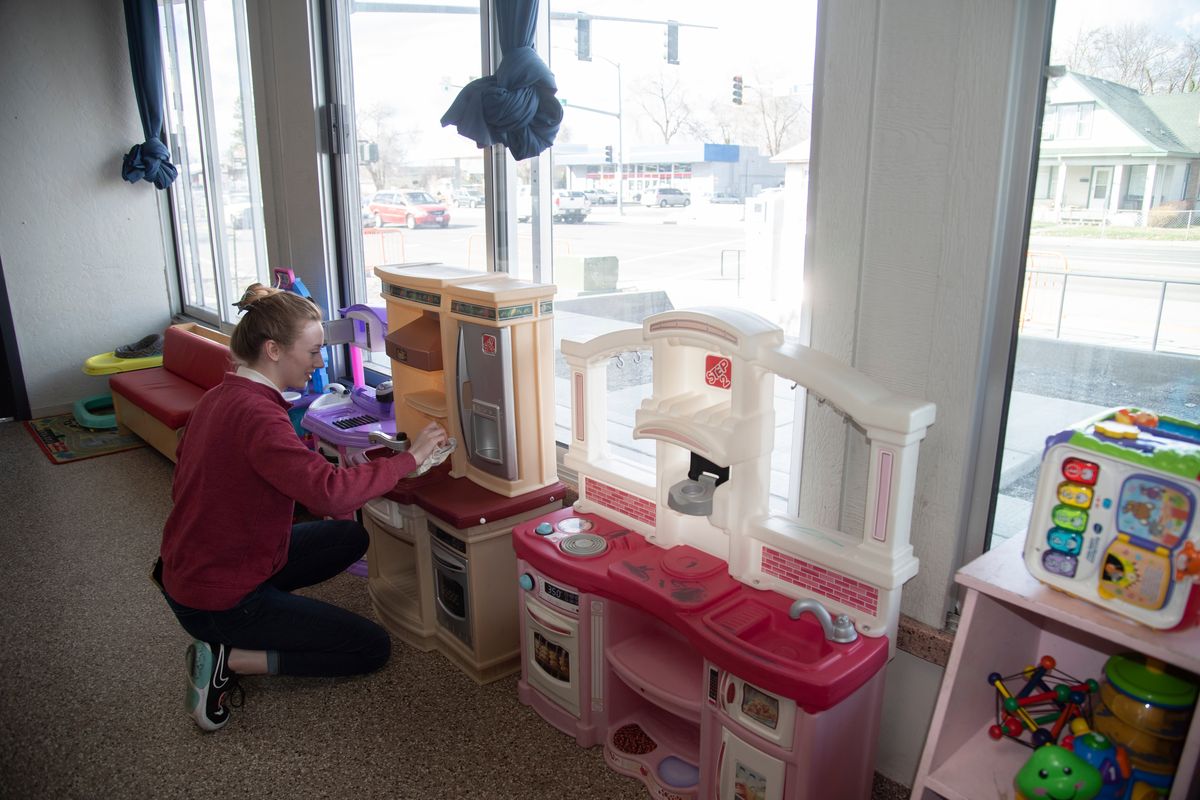 Whitworth University student and volunteer Trillium Bristow helps out by cleaning toys at the Family Promise shelter at 2002 E. Mission Ave. on March 15, 2022.  (Jesse Tinsley/The Spokesman-Review)