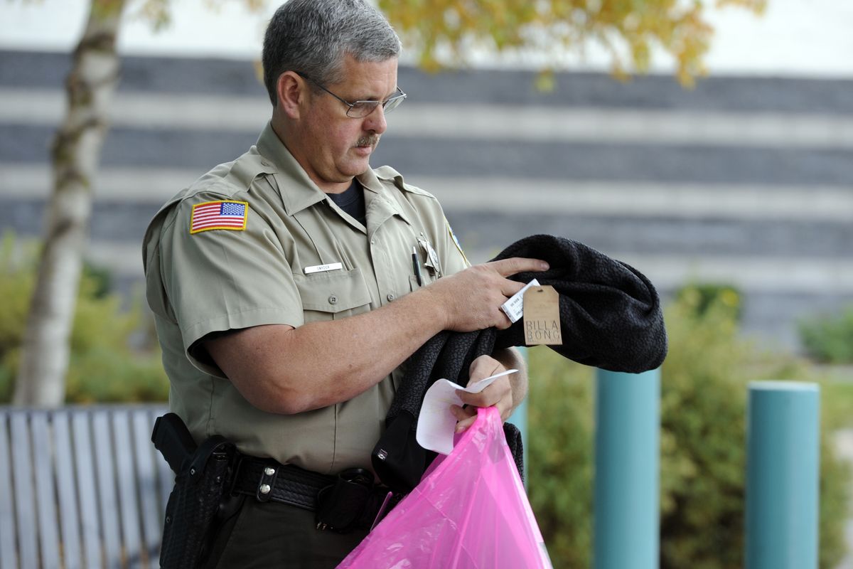 Spokane County Sheriff’s Deputy Greg Snyder looks inside the shopping bag of a suspected shoplifter outside the Spokane Valley Mall Tuesday. Snyder and Travis Pendell are crime prevention officers who work out of a small office at the Spokane Valley Mall and occasionally assist mall security with crimes around the mall. (Jesse Tinsley)