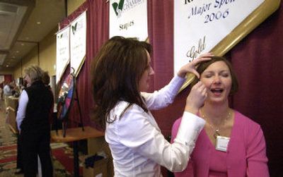 
Andrea Bates grimaces as licensed esthetician Elina Yurkin finishes waxing her eyebrows at the Brick House Massage and Coffee Bar's booth at the Spokane Valley  Business Fair at Mirabeau Park Hotel. 
 (Liz Kishimoto / The Spokesman-Review)