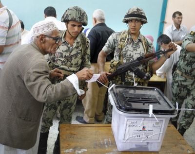 An Egyptian casts his vote in front of soldiers at a polling station in Zagazig, 63 miles northeast of Cairo, on Saturday. The two-day balloting will produce Egypt’s first president since a popular uprising last year ousted Hosni Mubarak, who is now serving a life sentence. (Associated Press)