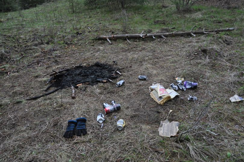 Alcoholic beverage cans, a ripped up phone book and other garbage along with an illegal fire mar a site that had just been cleaned up the previous weekend in the Dishman Hills Natural Area in April, 2011. (Rich Landers)