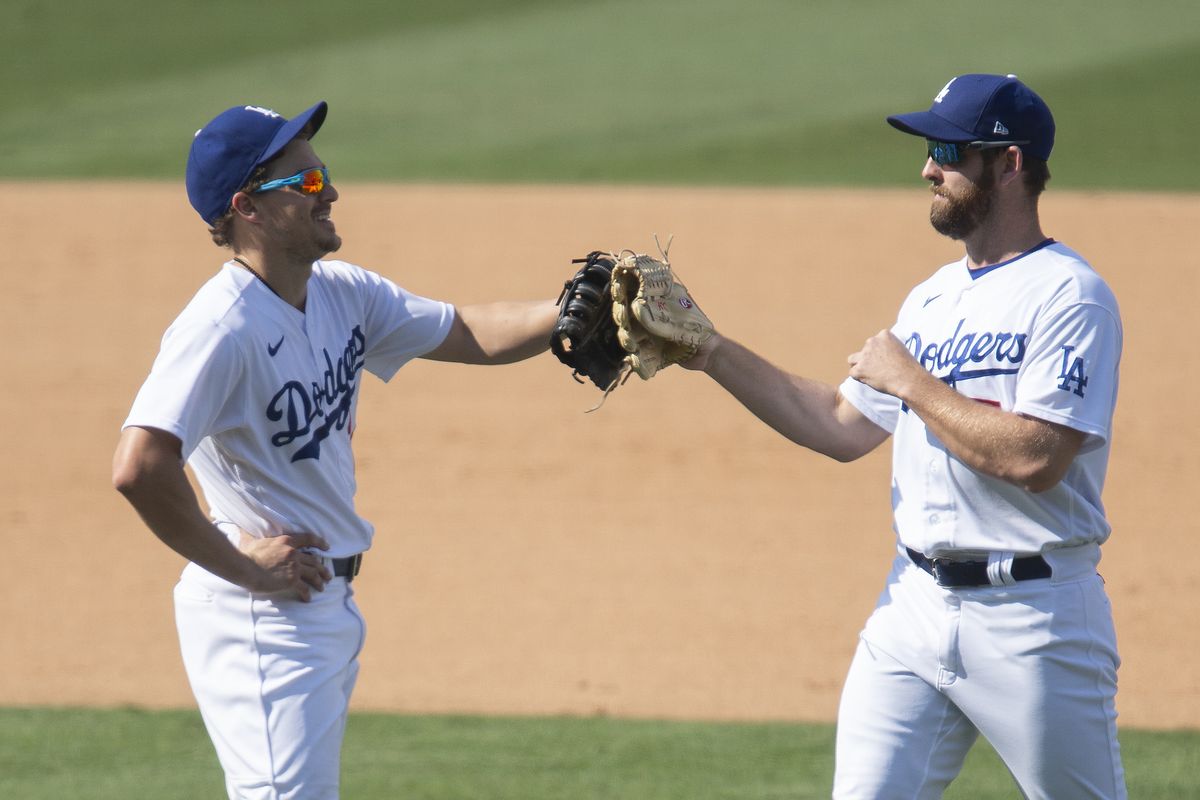 Los Angeles Dodgers first baseman Enrique Hernandez, left, and right fielder Adam Kolarek celebrate their win over the Los Angeles Angels in a baseball game in Los Angeles, Sunday, Sept. 27, 2020.  (Kyusung Gong)