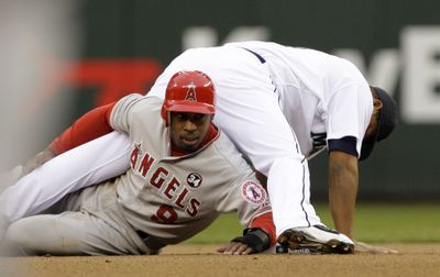 Chone Figgins of the Angels gets tangled with Mariners second baseman Jose Lopez during first-inning play.   (Associated Press / The Spokesman-Review)