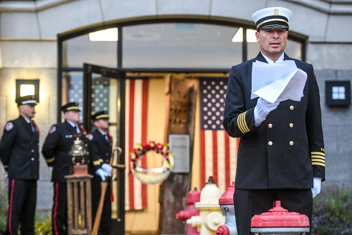 Spokane Valley Fire Department Deputy Chief Frank Soto Jr. honors the 343 firefighters lost on Sept. 11, 2001, in the collapsed Twin Towers, by reading their names during a bell-ringing ceremony in remembrance of 9/11, Saturday at the SVFD Administration Building. A 1,200-pound column from one of the Twin Towers is installed in the entry way behind Soto.  (DAN PELLE/THE SPOKESMAN-REVIEW)