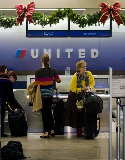 Travelers check in for their flights at the United Airlines ticket counter at John Wayne Airport in Orange County, Calif., in November. (Associated Press)