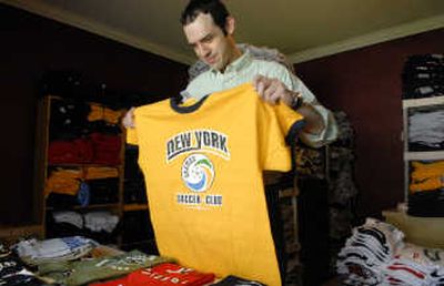 
Robert Shugert folds a New York Cosmos soccer shirt that his company sells at throwbackmax.com. The company offers vintage-style athletic apparel. 
 (Photos by DAN PELLE / The Spokesman-Review)