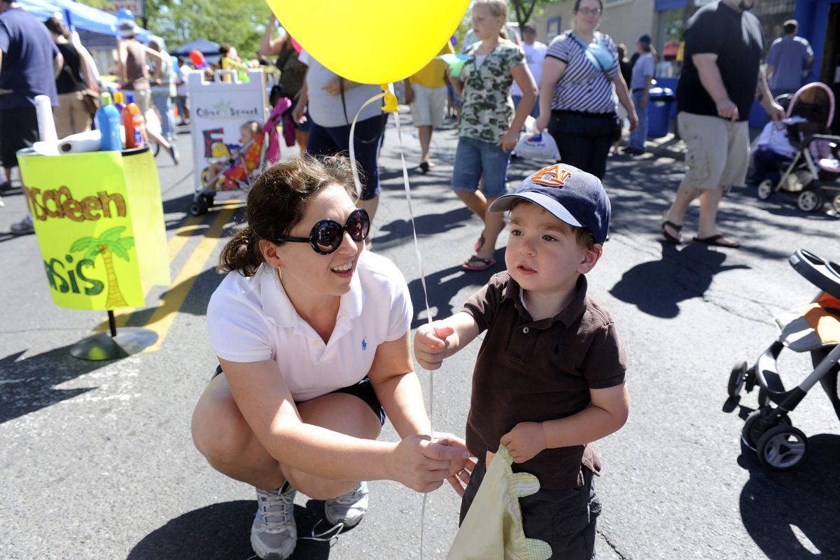 Melinda Nix helps her son, 2-year-old Otis Nix, accept a free balloon  at the Garland Street Fair on Saturday.  (photos by JESSE TINSLEY)
