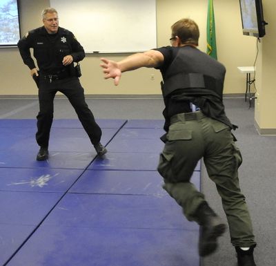 Deputy Eric Johnson, left, creates distance between himself and a knife-holding fellow deputy, Mike Brooks, during a demonstration at the Spokane County Sheriff's Office Training Center.  (Dan Pelle / The Spokesman-Review)