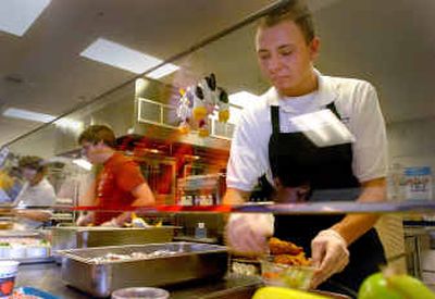 
Barry Dulay serves lunch in Lake City High School's cafeteria Friday. Dulay, who worked in various jobs as part of the school's Community Based Instruction program, was invited back to work at the school after his graduation.
 (Jesse Tinsley / The Spokesman-Review)
