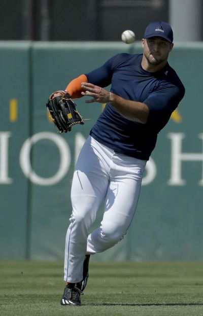 Former NFL quarterback Tim Tebow fields the ball during tryout for baseball scouts and the media on the campus of the University of Southern California on Tuesday. (Chris Carlson / Associated Press)