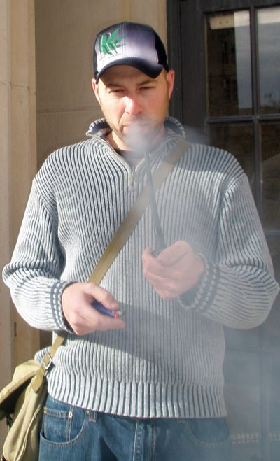 Jason Christ smokes a bowl of marijuana in front of the civic center in downtown Great Falls on Oct. 23, 2009. (Associated Press)