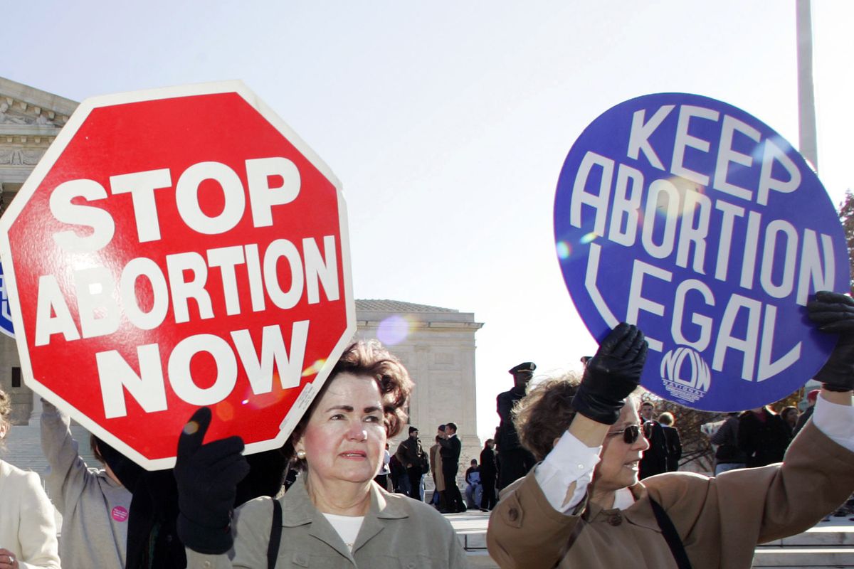 In this Nov. 30, 2005 photo, an anti-abortion supporter stands next to a pro-choice demonstrator outside the U.S. Supreme Court in Washington. The new poll from The Associated Press-NORC Center for Public Affairs Research finds 61% of Americans say abortion should be legal in most or all circumstances in the first trimester of a pregnancy. However, 65% said abortion should usually be illegal in the second trimester, and 80% said that about the third trimester.  (Manuel Balce Ceneta)