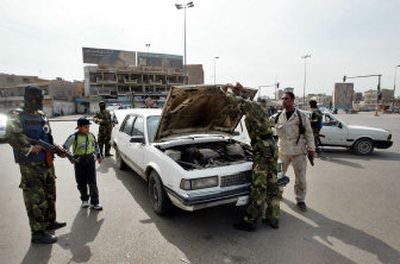 
Iraqi policemen check a car during a curfew in Baghdad, Iraq Sunday. Bomb blasts and gunfire killed at least 26 people, including three U.S. soldiers, in Baghdad and south of the capital Sunday. 
 (Associated Press / The Spokesman-Review)