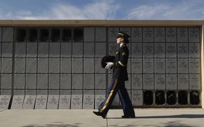 Sgt. Arwen Ratto, of the 183rd Aviation Battalion of the Idaho Army National Guard, carries the remains of Vietnam Army veteran Spec. Larry Markham to their final resting place during an interment ceremony Friday. (Associated Press / The Spokesman-Review)