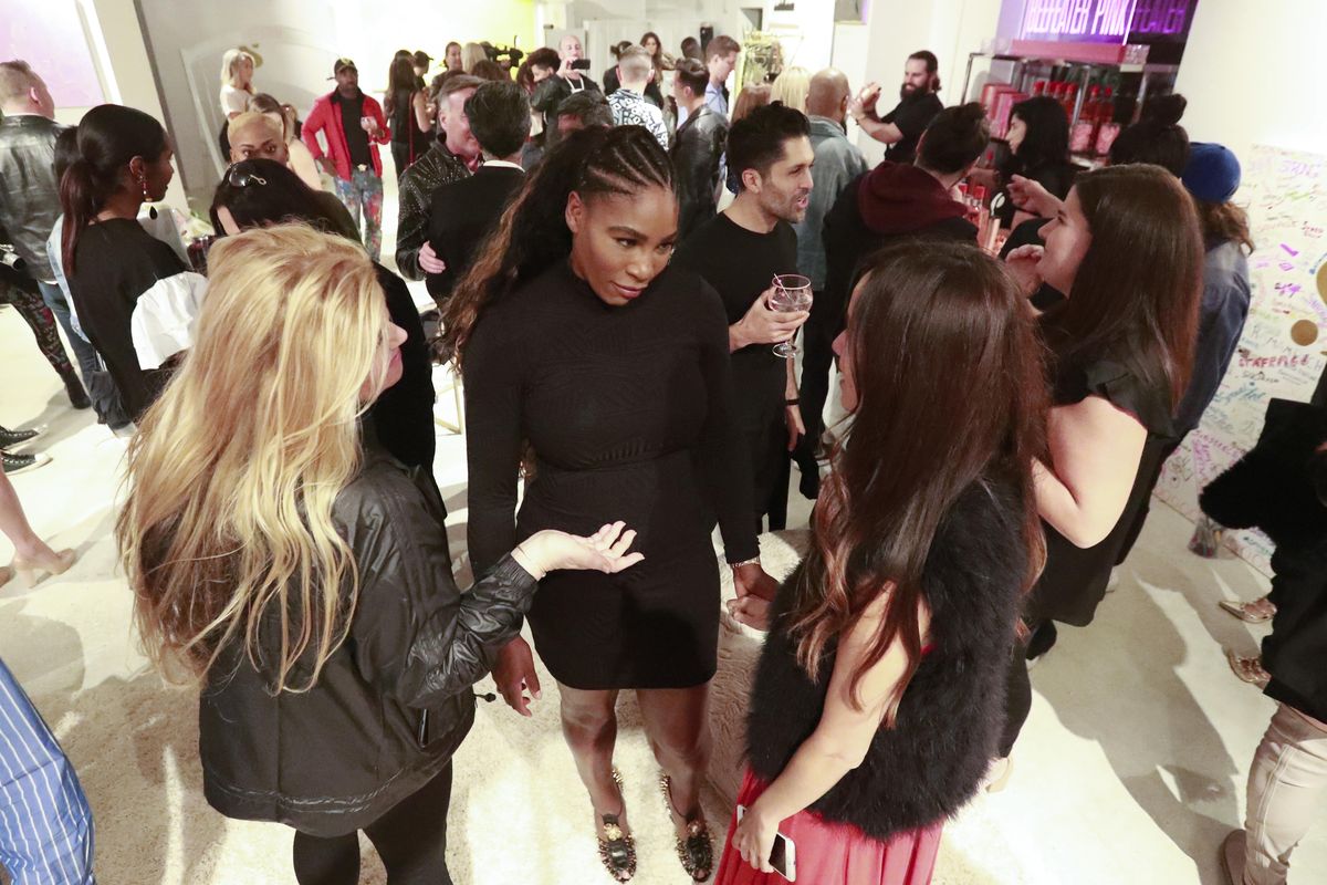 In this, Wednesday, Dec. 5, 2018 photo, tennis player Serena Williams, center, mingles with guests during the launch of her first pop-up shop at the Faena Bazaar in Miami Beach, Fla. The 23-time Grand Slam-event champion not only designed all the clothing in the shop, but also painted all the art on walls, calling painting her outlet. (Wilfredo Lee / Associated Press)