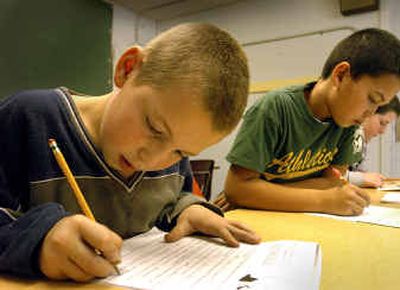 
Fifth-graders Steve Harmon, left, Travis Tackett, center, and Lucas Rencher work on language arts assignments at Hayden Lake Elementary on Tuesday. The school posted significant improvement in reading and math scores on the ISAT test, partly because of their small-group emphasis sessions. The test is required under the No Child Left Behind Act. 
 (Jesse Tinsley / The Spokesman-Review)