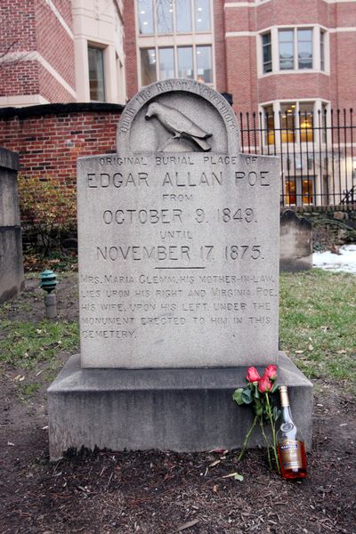 A 2008 file photo shows the original grave of Edgar Allan Poe, with a bottle of cognac and roses left by a mysterious visitor, in Baltimore. (Associated Press)