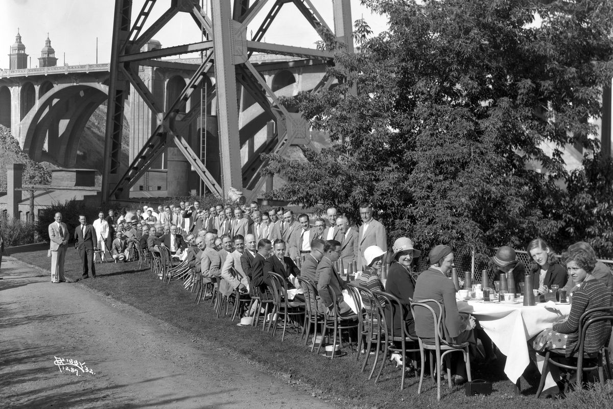 Members of the newly-formed Inland Empire Early Birds Breakfast Club hold one of their first meetings beside the falls, and under the railroad trestle going to the Union Depot, in June of 1932. The civic and social club focused on business networking, but eventually had a meeting room and bar in the basement of the Davenport Hotel where clubmembers socialized. The Early Birds Club closed down in 1968. (Libby Collection/Eastern Washington Historical Society / SR)