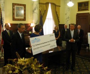 Gov. Butch Otter, at right, welcomes a record dividend from Idaho's state lottery; at left is Lottery Director Jeff Anderson, and at center, Idaho State Department of Education official Luci Willits. (Betsy Russell)