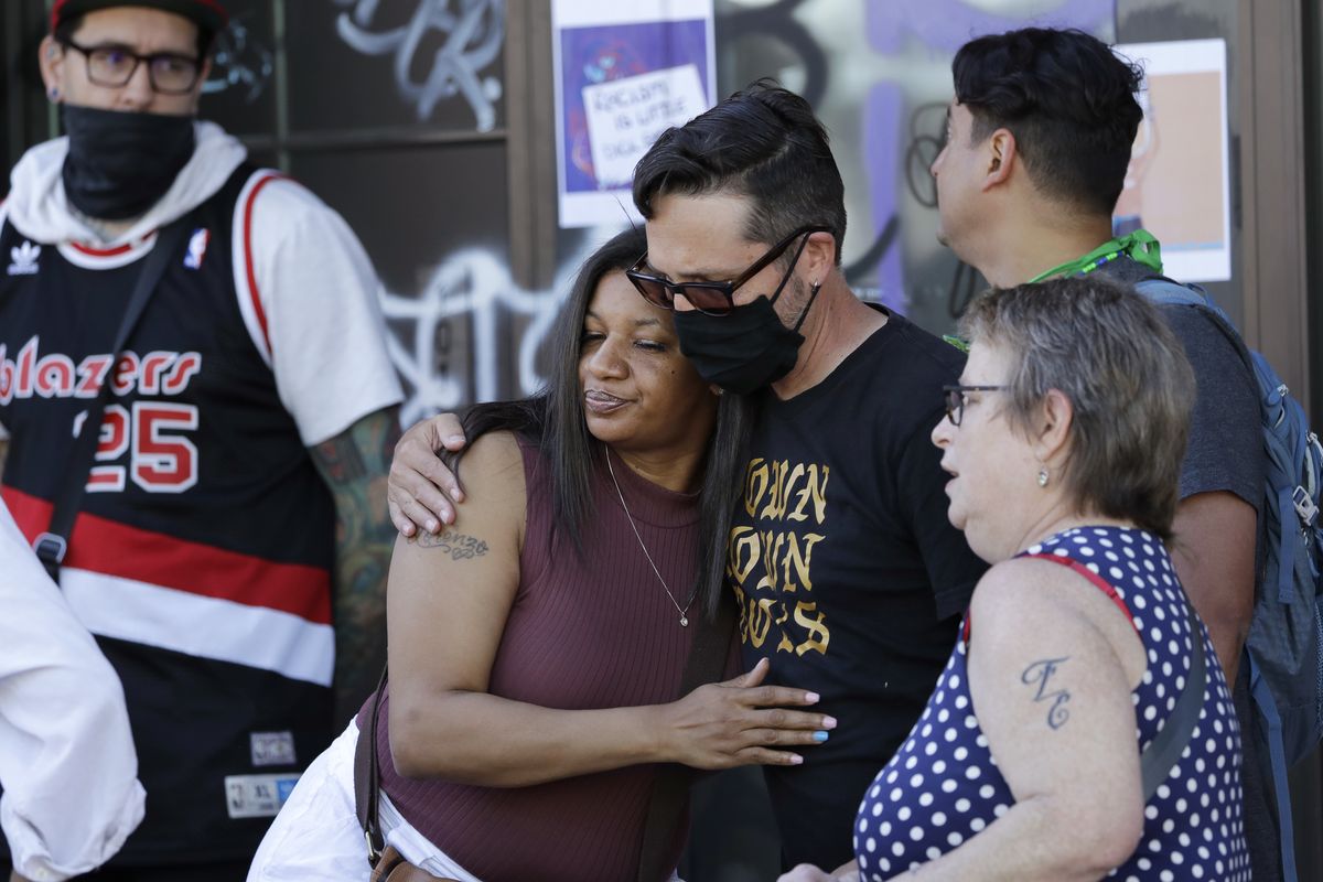 Donnitta Sinclair, center, mother of Lorenzo Anderson, who was killed nearby by gunfire days earlier, is comforted by others while visiting the area on June 23 in Seattle, where streets were blocked off in what was named the Capitol Hill Occupied Protest zone. (Elaine Thompson)