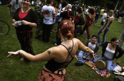
Chandra Lynn Roberts, 23, dances to the beat of the drums at Manito Park on Thursday evening along with more than 100 others. Recently there have been complaints from local residents that a few troublemakers in the group have been leaving trash and staying after the 10 p.m. park closing.  