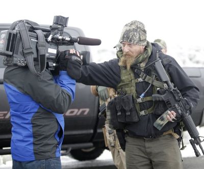 A man standing guard pushes a videographer aside after members of the 