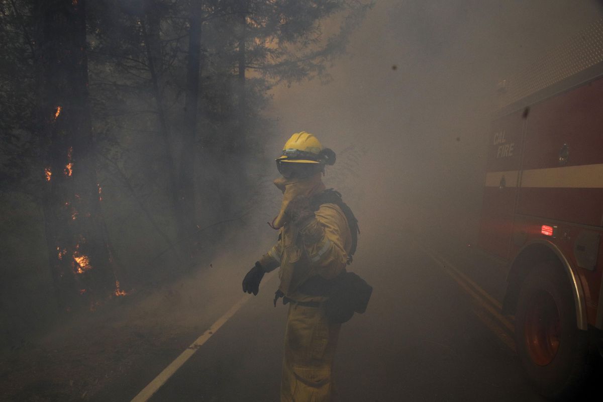 A firefighter gestures to his colleagues as he walks through thick smoke from a wildfire Thursday, Oct. 12, 2017, near Calistoga, Calif. (Jae C. Hong / Associated Press)