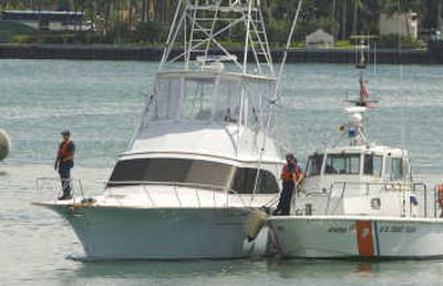 
The sport fishing yacht Joe Cool, left, is towed into the Miami Beach Coast Guard station on Tuesday. Four crew members were missing from the yacht, which was found adrift. Associated Press
 (Associated Press / The Spokesman-Review)