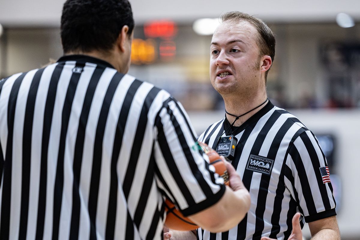 Basketball officials Josh Davis, left, and Tim Lewis talk during a break in the second half of the boys varsity match between Lewiston and Clarkston high schools on Jan. 26 in Lewiston, Idaho.  (Cole Quinn/For The Spokesman-Review)