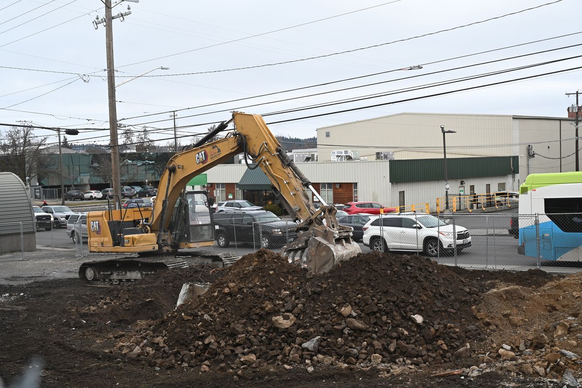 An excavator works at the corner of Maple Street and Maxwell Avenue on Wednesday and continues removing a building that was once associated with an asbestos plant there. The land now belongs to Spokane County.  (Jesse Tinsley/THE SPOKESMAN-REVIEW)