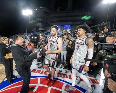 Gonzaga forward Drew Timme, left, and guard Julian Strawther receive the championship trophy after defeating Michigan State 64-63 during the Armed Forces Classic Friday in San Diego.  (Colin Mulvany / The Spokesman-Review)